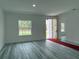 Bright, open-concept living room features gray wood-look floors, white walls, and a unique front door at 538 Marion Oaks Blvd, Ocala, FL 34473