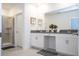 Bright bathroom featuring a double vanity, white cabinets, and a glass-enclosed shower at 540 Sticks St, Davenport, FL 33896