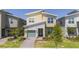 Modern two-story home with stone accents, manicured lawn, and a green two car garage door at 540 Sticks St, Davenport, FL 33896