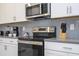 Modern kitchen with stainless steel appliances, gray backsplash, and white cabinets at 540 Sticks St, Davenport, FL 33896