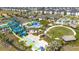 Aerial view of resort-style pool with slides, splash pad, and modern townhome community at 540 Sticks St, Davenport, FL 33896