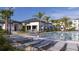 Community pool featuring lounge chairs, dining tables, and lush palm tree landscaping at 540 Sticks St, Davenport, FL 33896