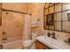 Stunning bathroom featuring travertine tile, shower-tub, and decorative light fixture and mirror at 5719 Emerson Pointe Way, Orlando, FL 32819