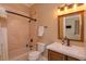 Well-lit bathroom showcasing marble tiled shower-tub and custom vanity with a bronze faucet and accents at 5719 Emerson Pointe Way, Orlando, FL 32819