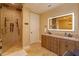 Bright bathroom featuring double vanity sinks, a walk-in shower, and neutral tile flooring at 5719 Emerson Pointe Way, Orlando, FL 32819