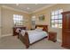 Sunny bedroom with traditional furnishings, including a wooden bed frame, dresser, and bedside tables at 5719 Emerson Pointe Way, Orlando, FL 32819