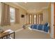 Another staged bedroom with a large array of windows, plus a bed and desk against light yellow walls at 5719 Emerson Pointe Way, Orlando, FL 32819