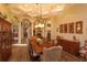 Formal dining room with coffered ceilings, wood floors, and a long table with seating for ten at 5719 Emerson Pointe Way, Orlando, FL 32819