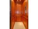 A private elevator featuring an elevator car lined with hardwood panels, plus a button panel and handle at 5719 Emerson Pointe Way, Orlando, FL 32819