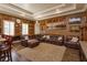 Spacious living room with a brown leather sectional sofa and a wall of framed artwork at 5719 Emerson Pointe Way, Orlando, FL 32819