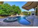 A luxury pool featuring a built-in fountain and spa, complemented by a covered gazebo and lush landscaping at 5719 Emerson Pointe Way, Orlando, FL 32819