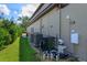 Exterior side yard showing mechanical equipment with AC units, filtration system and lush landscaping at 5719 Emerson Pointe Way, Orlando, FL 32819