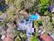 An aerial view of a home featuring a private pool surrounded by lush, mature trees at 621 Daron Ct, Winter Springs, FL 32708