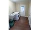 Bright laundry room with white washer and dryer, utility sink, wood-look flooring, and access to the backyard at 621 Daron Ct, Winter Springs, FL 32708