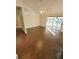 Living area with wood-look floors, neutral walls, and sliding glass doors leading to a sunroom at 621 Daron Ct, Winter Springs, FL 32708