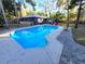 A sparkling blue pool surrounded by lush greenery and a paved deck with lounge chairs at 621 Daron Ct, Winter Springs, FL 32708