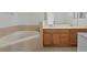 Well-lit bathroom with double vanity, a soaking tub, and neutral-toned tile at 701 Fortanini Cir, Ocoee, FL 34761