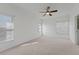 Spacious bedroom featuring neutral carpeting, white walls, and a ceiling fan at 701 Fortanini Cir, Ocoee, FL 34761