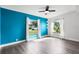 Light-filled bedroom with sleek flooring and a striking blue accent wall and bright windows at 704 Baywood Dr, Sanford, FL 32773