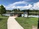 Outdoor lake dock in a neighborhood with blue skies and bright green grass at 704 Baywood Dr, Sanford, FL 32773