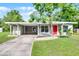 Inviting single-story home featuring a carport, well-maintained lawn, and vibrant landscaping at 704 Baywood Dr, Sanford, FL 32773