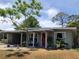 Charming single story home featuring a front yard, a red door with a wreath, and a covered carport at 704 Baywood Dr, Sanford, FL 32773