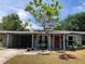 Charming single story home featuring a front yard, a red door with a wreath, and a covered carport at 704 Baywood Dr, Sanford, FL 32773