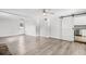 Open living room with wood flooring, barn door, and bright kitchen area at 704 Baywood Dr, Sanford, FL 32773