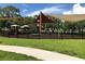 playground in a community park with dark metal fencing and mature trees at 704 Baywood Dr, Sanford, FL 32773