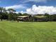 playground in a park with shade covers, lush green grass, and tall trees at 704 Baywood Dr, Sanford, FL 32773