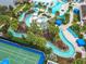 Aerial view of a resort-style pool, lazy river with cabanas, and sports court, nestled in a community near a serene lake at 8941 Rhodes St, Kissimmee, FL 34747