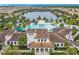 Aerial view showcases a spacious clubhouse and pool area with a splashpad, and a scenic lake as a backdrop at 8941 Rhodes St, Kissimmee, FL 34747