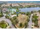 An aerial view of a community clubhouse, playground, and splashpad alongside a serene lake and lush landscapes at 8941 Rhodes St, Kissimmee, FL 34747