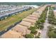 Expansive aerial view of a neighborhood featuring tile roofs, green spaces, and a tranquil lake at 8941 Rhodes St, Kissimmee, FL 34747