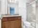 Bathroom with wood vanity, granite countertop, modern fixtures, and glass shower at 8941 Rhodes St, Kissimmee, FL 34747