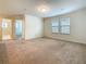 Bedroom with carpeted floor, windows for natural light, and doorway to bathroom at 8941 Rhodes St, Kissimmee, FL 34747