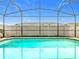 Sparkling in-ground pool enclosed by a screen, providing a private backyard oasis at 8941 Rhodes St, Kissimmee, FL 34747