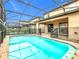 Private in-ground pool featuring a screened enclosure and an expansive patio at 8941 Rhodes St, Kissimmee, FL 34747