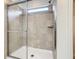 Tiled shower with sliding glass door and window for natural light at 8941 Rhodes St, Kissimmee, FL 34747