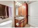 Bathroom with granite-topped sink, medicine cabinet, and brown and purple towels at 912 Charo Pkwy # 214, Davenport, FL 33897