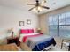 This is a bedroom with a ceiling fan and a large window with blind shade at 912 Charo Pkwy # 214, Davenport, FL 33897