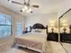 Bedroom featuring a ceiling fan, windows, and carpet at 912 Charo Pkwy # 214, Davenport, FL 33897