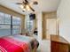 Bright bedroom features a large window, ceiling fan, and adjacent bathroom at 912 Charo Pkwy # 214, Davenport, FL 33897