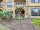 Inviting exterior of a condo building entrance with a stone facade and landscaped garden area at 912 Charo Pkwy # 214, Davenport, FL 33897