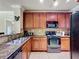 The kitchen includes wood cabinets, granite counters, stainless steel appliances, and tile flooring at 912 Charo Pkwy # 214, Davenport, FL 33897