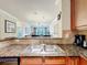 Kitchen with granite countertop, stainless steel sink, and views of the living area at 912 Charo Pkwy # 214, Davenport, FL 33897