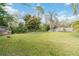 Large grassy backyard with a wood fence, flowering trees, and abundant greenery at 965 Rosinia Ct, Orlando, FL 32828