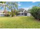 Expansive backyard featuring a well-maintained lawn and tropical landscaping at 965 Rosinia Ct, Orlando, FL 32828