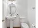 Bathroom with a pedestal sink, oval mirror, toilet, wood-look tile flooring, and white walls at 965 Rosinia Ct, Orlando, FL 32828