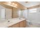 Bathroom featuring double sinks, large mirror, and tiled shower and floors at 965 Rosinia Ct, Orlando, FL 32828